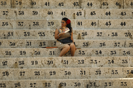 A woman fans herself as she waits for the start of a bullfight at the Malagueta bullring in Malaga