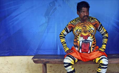 A dancer in body paint waits for his performance during festivities marking the start of Onam in Kochi