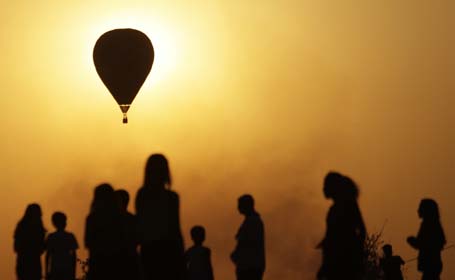 Spectators look at contestants competing in the National Ballooning Championship, held to commemorate Brazil's independence day, in Brasilia