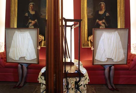 Kate Bain from Lyon and Turnbull auctioneers poses for photographers with a framed pair of silk bloomers undergarments that once belonged to Queen Victoria during a photocall for the auction of the Forbes Collection in Edinburgh, Scotland