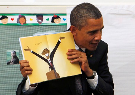 U.S. President Barack Obama holds up book in a children's classroom at Eastfield College in Texas