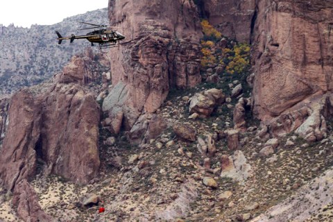 A Maricopa Sheriff helicopter recovers a body from the Superstition Mountains where rescue workers searched for victims of a plane crash in Apache Junction