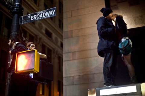 Protesters affiliated with the Occupy Wall Street movement kiss while standing on top of a bus stop outside Zuccotti Park in New York