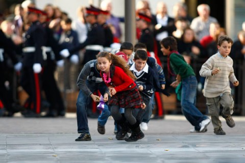 Children rush onto the parade ground to collect spent rifle cartridges after an Armed Forces of Malta military parade to mark Malta's Republic Day in Valletta