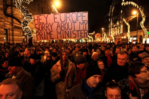 A man holds up a sign during a protest in central Budapest