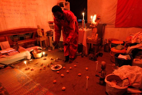 Azaelis, a spiritual medium, prepares a mock soccer stadium with mystical effigies inside his shrine in Libreville