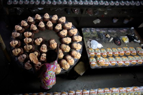 A worker prepares masks in the likeness of Brazilian President Dilma Rousseff at a factory assembly line in Sao Goncalo
