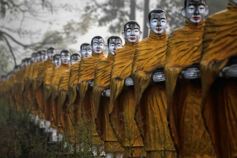 Statues of Buddhist monks are lined near a temple in Payathonzu, near the Burmese border with Thailand