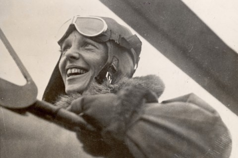 Aviatrix Amelia Earhart in cockpit of plane.