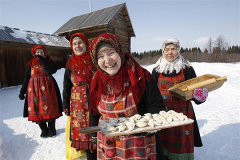 Byagisheva, Shklayeva, Dorodova and Baisarova, members of the singing group "Buranovskiye Babushki", offer home made dumplings at a folk museum near the village of Ludorvai