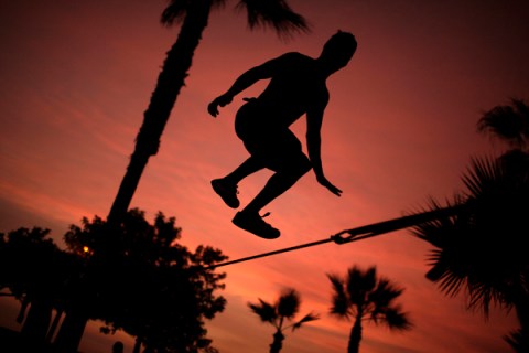 A man performs on the slackline at a park in Lima