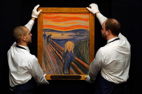 Sotheby's employees pose for a photograph with Edvard Munch's painting "The scream" at Sotheby's auction house in London