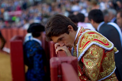 French matador Castella leans over the barrier during a bullfight in The Maestranza bullring in Seville