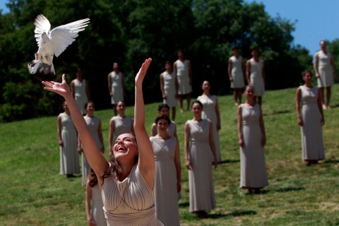 An actress, playing the role of a priestess, releases a dove during the dress rehearsal for the torch lighting ceremony of the London 2012 Olympic Games at the site of ancient Olympia in Greece