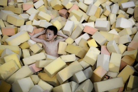 A young athlete from the provincial diving team rests on sponges during a training session at a training centre in Taiyuan