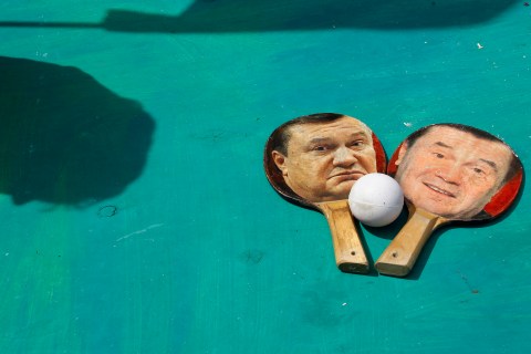Table tennis rackets with pictures of Ukraine's President Yanukovych are seen during a rally in a protest tent camp in central Kiev