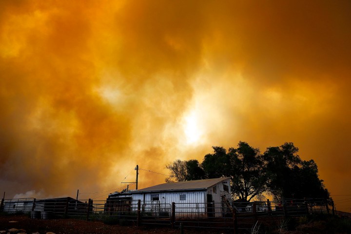 Smoke fills the air over a small barn turning the sky orange as the High Park Fire burns near Laporte, Colorado