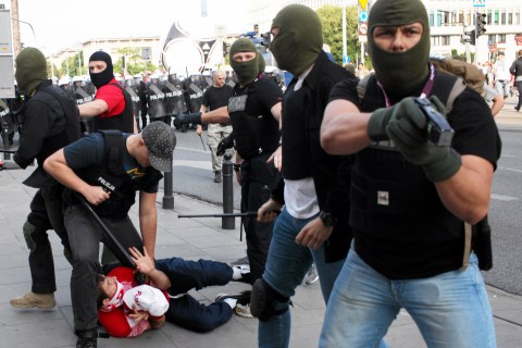 Police officers arrest  fan during clashes before Euro 2012 soccer match between Poland and Russia in Warsaw