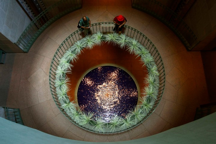 Visitors look down into a pool of water at the National Museum of African Art in Washington