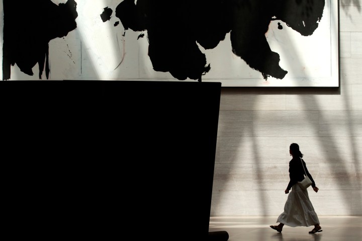 A woman passes between two works of art in the East Building of the National Gallery of Art in Washington