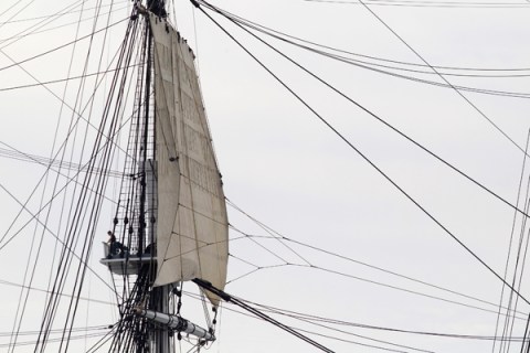 A sailor aboard the USS Constitution looks down on Boston Harbor as the USS Consititution sails under her own power for the first time since 1997, in Boston
