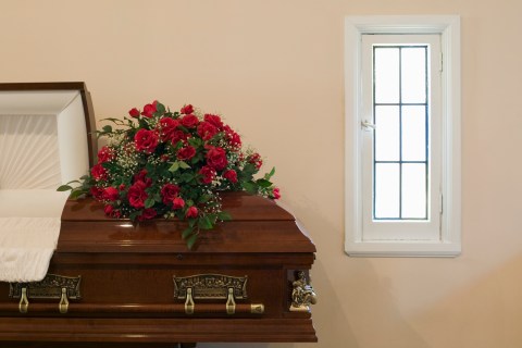 Flower arrangements on top of open coffin