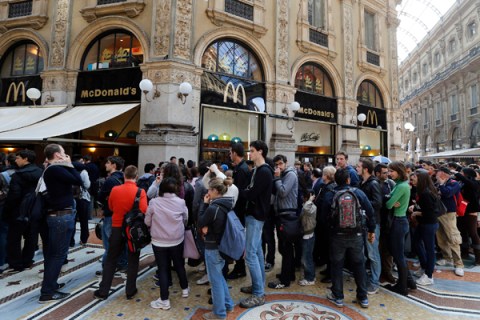 People queue for free meals outside a McDonald's fast food restaurant in downtown Milan