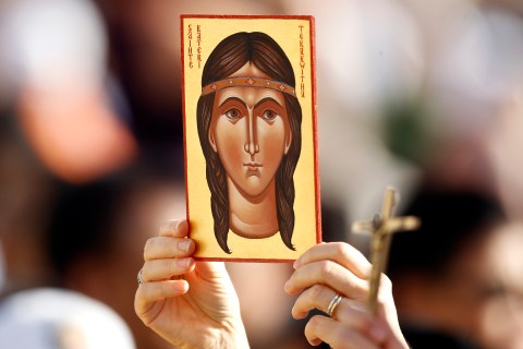 A faithful holds an image depicting Kateri Tekakwitha, the first ever native American to be declared a saint, before Pope Benedict XVI conducts a special mass to canonize seven new saints at St. Peter's square in Vatican City