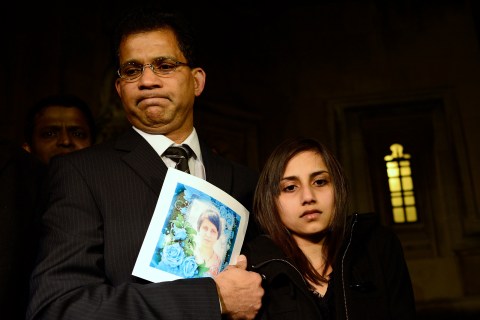 Lisha Barboza stands with her father Ben while he holds a picture of his wife, nurse Jacintha Saldanha, as they leave the Houses of Parliament in London