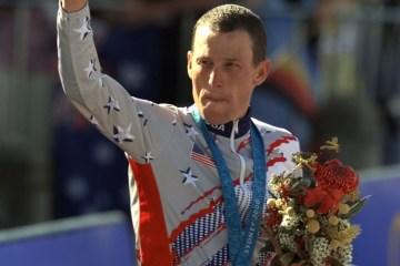 image: Lance Armstrong waves after receiving the bronze medal in the men's individual time trials at the 2000 Summer Olympics cycling road course in Sydney, Australia, Sept. 30, 2000.
