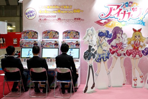 Visitors sit next to cardboard cutouts of anime characters at a booth at the Tokyo International Anime Fair in Tokyo