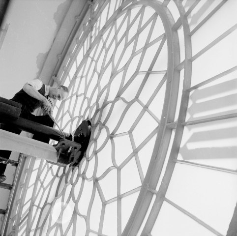 Technician Charles King carries out maintenance work behind the great clock face of Big Ben in the Palace of Westminster, London, 1957.
