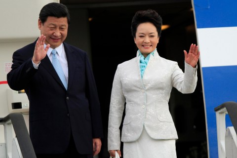 Chinese President Xi Jinping and First Lady Peng Liyuan wave from their plane upon their arrival at Julius Nyerere International Airport in Dar es Salaam