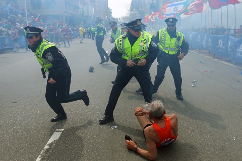 Police officers draw their weapons after hearing a second explosion near the finish line of the 117th Boston Marathon on April 15, 2013.