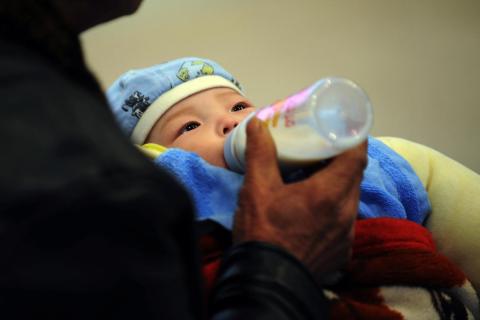 img: A baby drinks milk on February 2, 2010 in Wuhan, China.