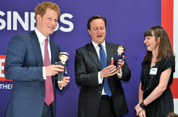 From left: Prince Harry and British Prime Minister David Cameron are presented with dolls of themselves by 'Makielab' company co-founder Jo Roach at the 'GREAT' event in New York City, on May 14, 2013.