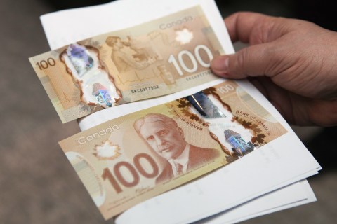 A man holds the new Canadian 100 dollar bills made of polymer in Toronto