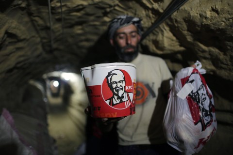 A smuggler carries food from Kentucky Fried Chicken to be delivered through an underground tunnel linking the Gaza Strip to Egypt, in Rafah, on May 13, 2013.