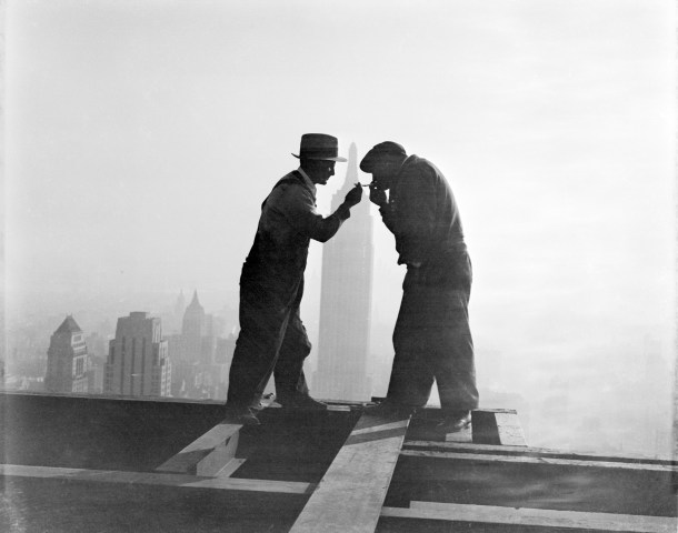 Two workmen share a cigarette atop the RCA Building in Rockefeller Center in front of the Empire State Building in New York City, on Dec. 2, 1932.
