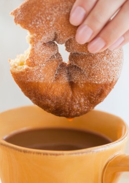 Doughnut being dunked in coffee