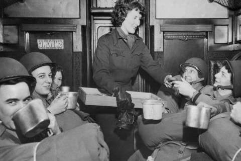 U.S. Army nurses have a repast of doughnuts and coffee on a troop train en route to their post in England after debarking from a transport, March 15, 1944