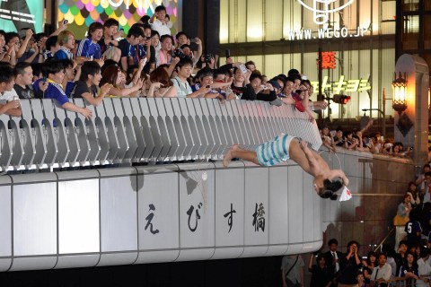 A Japanese soccer fan dives into Doton-bori river to celebrate Japan's qualification for the World Cup finals in Brazil in Osaka