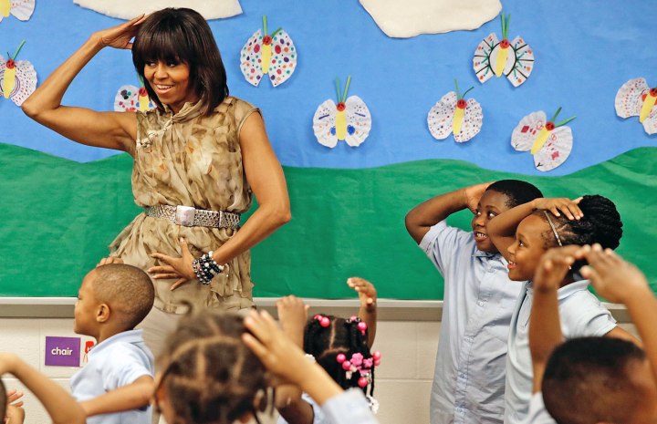 U.S. First Lady Michelle Obama dances with pre-kindergarten students while she visits the Savoy School in Washington, D.C., on May 24, 2013.