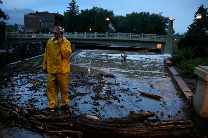 A city worker talks on his phone while surveying high water levels on Boulder Creek following overnight flash flooding in downtown Boulder, Colo., Sept 12, 2013. 