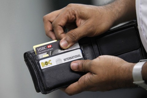 A man pulls out his credit card to make a purchase at a shop in Colombo