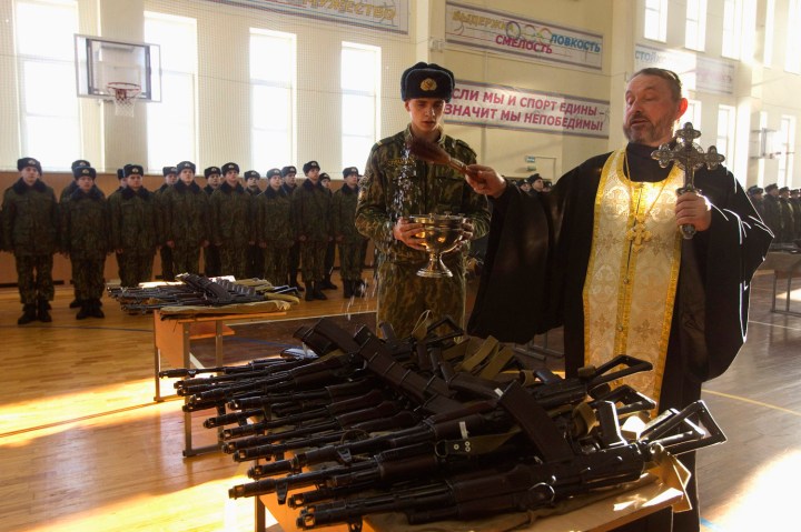 Orthodox priest blesses rifles during a ceremony where new recruits receive their weapons at a military base of Belarussian Interior Ministry in Minsk