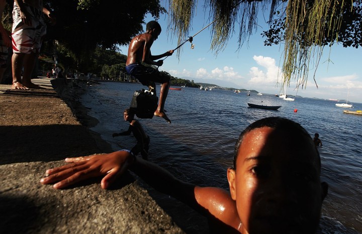 Kids play along the shoreline of Guanabara Bay in the Ilha do Governador neighborhood of Rio de Janeiro.on Jan. 21, 2014. 