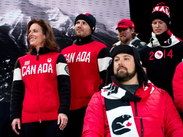 Curler Cheryl Bernard, left, and skier Jan Hudec, second left, and other athletes wear the new  Canadian Olympic and Paralympic team collection by Hudson's Bay that will outfit the athletes at the upcoming Sochi 2014 Olympic and Paralympic winter games, during a news conference Oct. 30, 2013, in Toronto. 