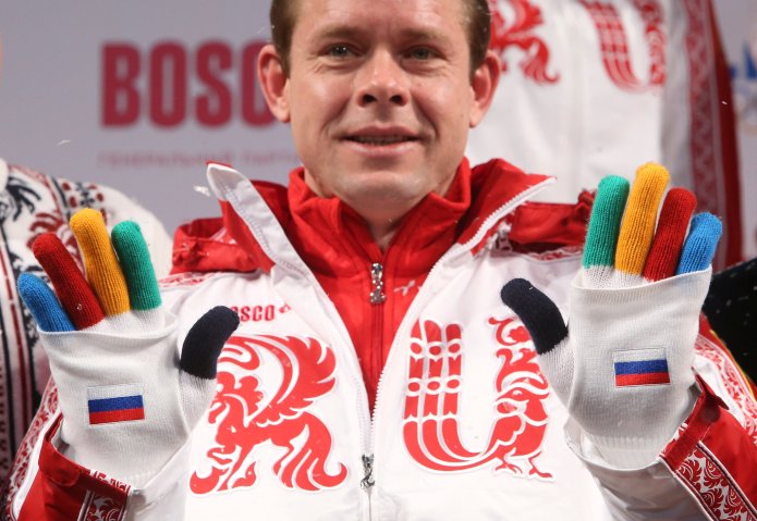 Former Russian ice-hockey player Bure shows a pair of gloves during a presentation of Russia's uniform for the Sochi 2014 Winter Olympics in Moscow