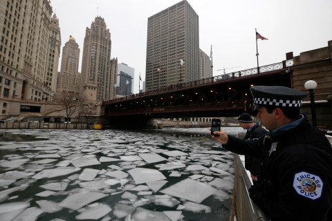 A police officer stops to photograph the cracked ice in the Chicago River